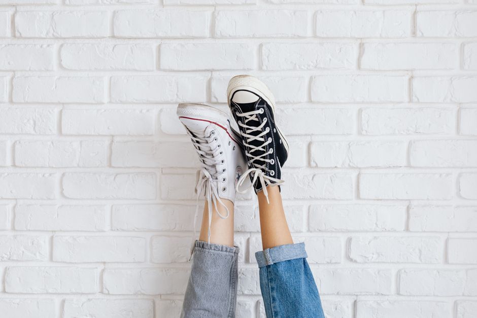 Casual sneakers pair showcased against a stylish white brick wall background.