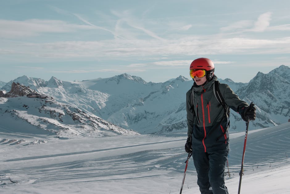 A skier enjoying the snowy slopes with alpine mountain views under clear skies.