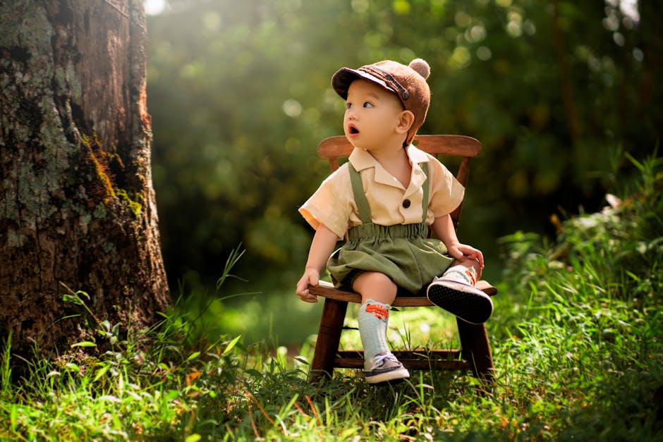 Adorable toddler sitting on a wooden stool in a lush forest setting enjoying nature.