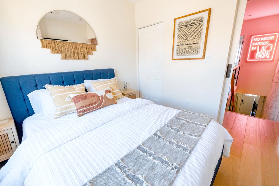 Bright modern bedroom design featuring stylish decor and neon wall art.