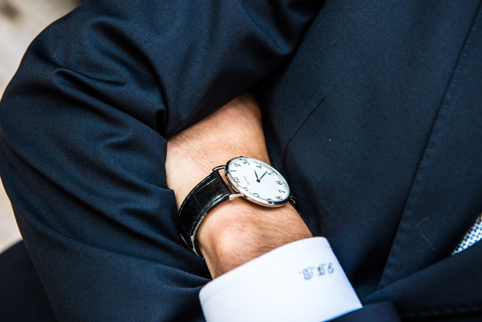 An elegant close-up of a man wearing a wristwatch, showcasing style and business appeal.