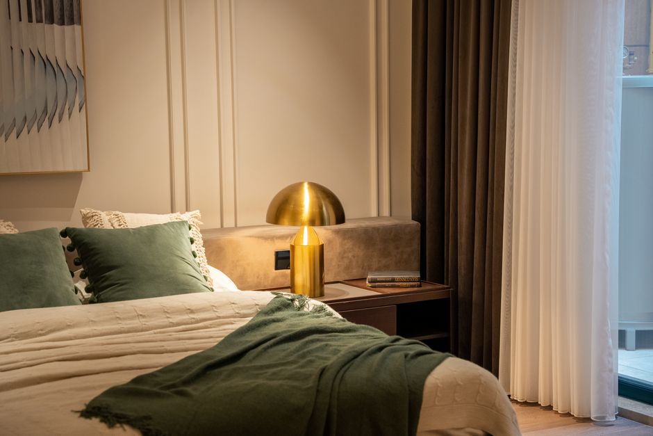 Cozy and elegant bedroom interior showcasing modern design with green accents and luxurious decor.