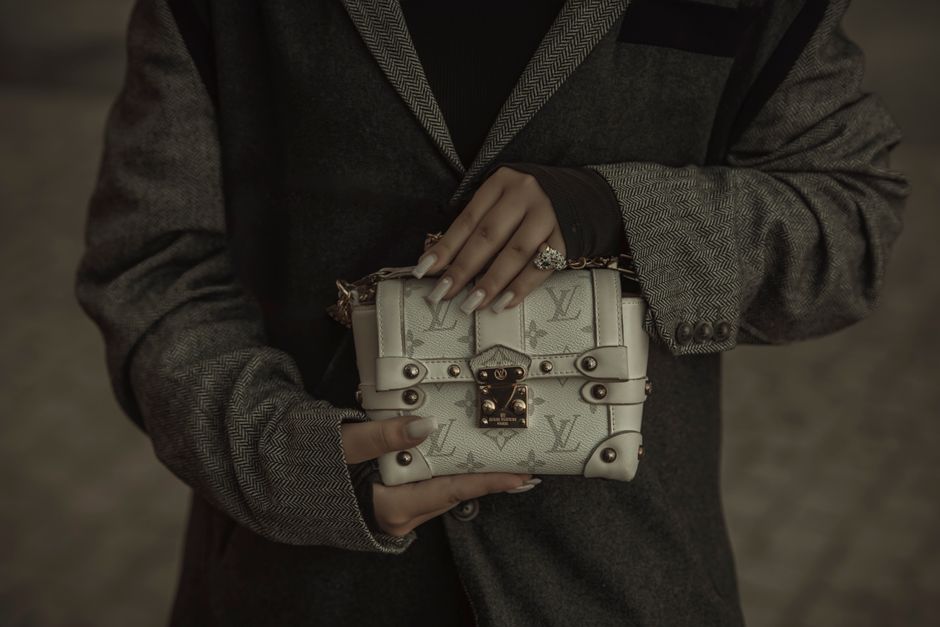 Close-up of a woman holding an elegant designer handbag, showcasing luxury fashion.