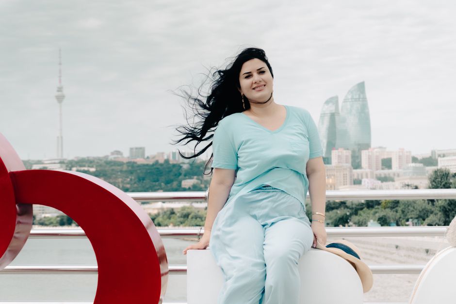 Woman posing outdoors in Baku with iconic Flame Towers in the background, showcasing modern Azerbaijan architecture.