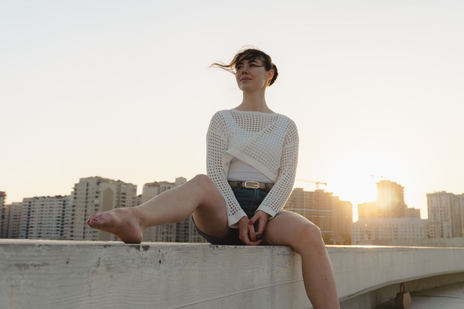 Sheer shirt layered under a knit sweater