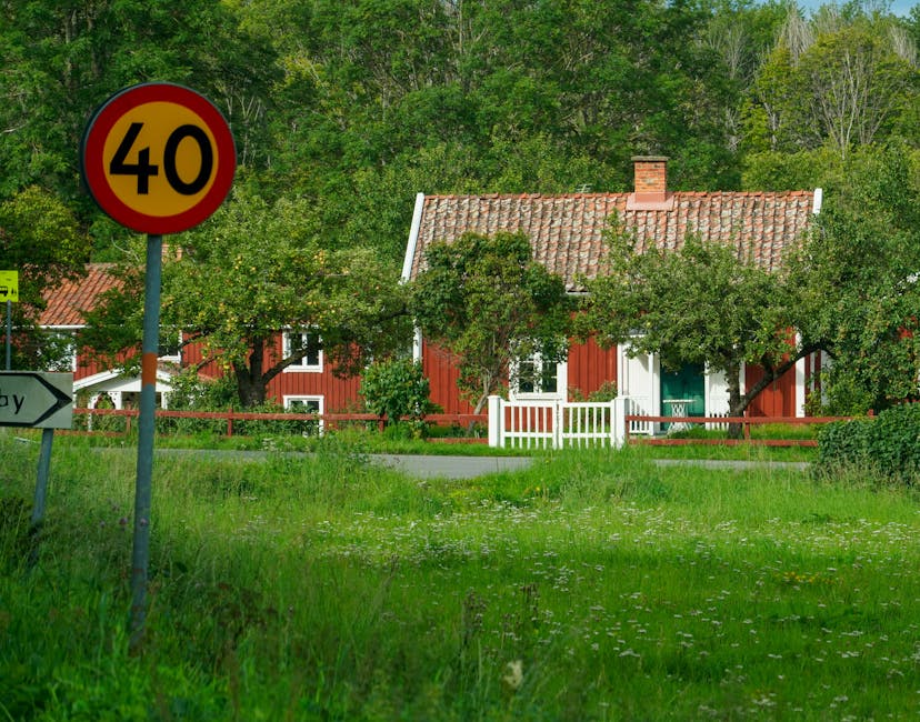 Picturesque rural scene with a charming house and speed limit sign in a lush green setting.